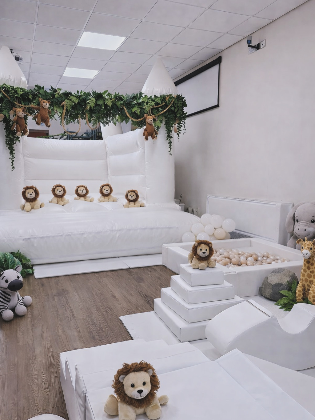 Safari themed luxury party setup with white bouncy castle and soft play