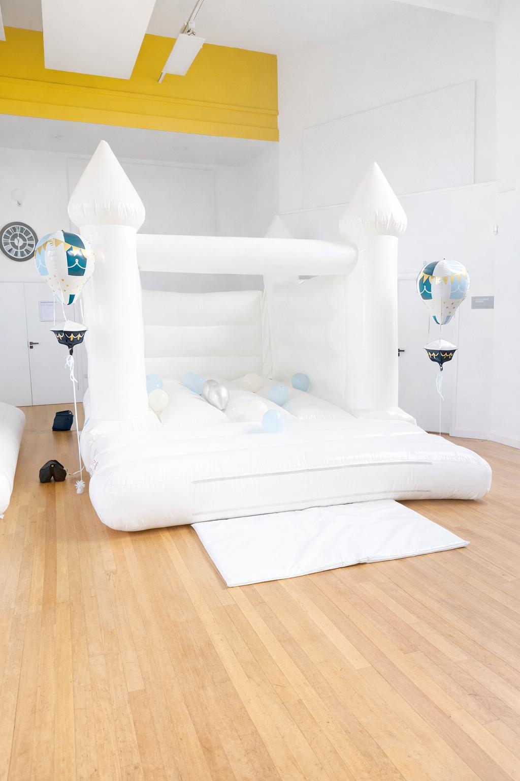 Clean all-white bouncy castle set up elegantly for a christening