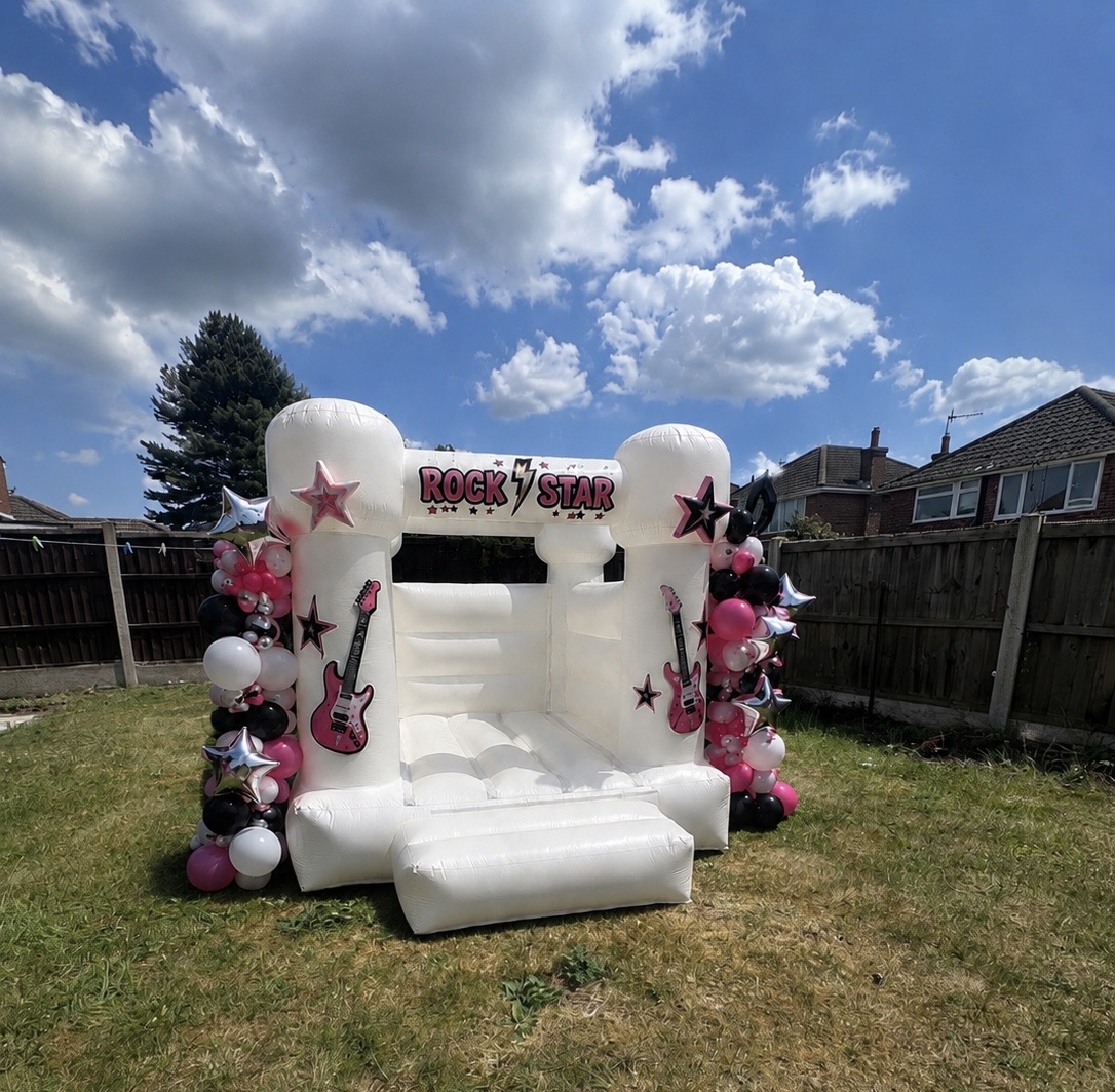 Rock star themed white bouncy castle with pink and black balloons